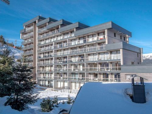 un grande edificio con la neve davanti di Magnifique appt au cœur de Courchevel avec accès bien-être - FR-1-562-81 a Courchevel