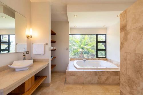 Un baño con bañera y una gran ventana. en Casa Turrialba, en Turrialba