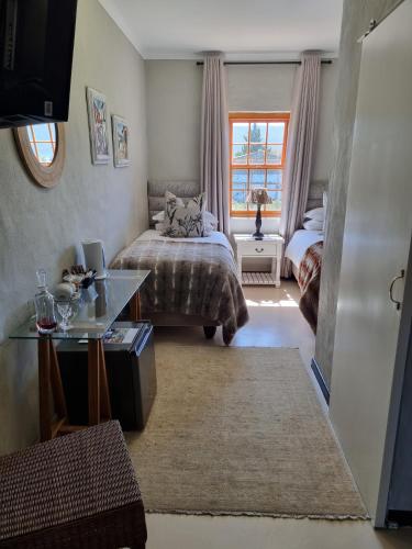 a bedroom with a bed and a desk and a window at Barrydale Karoo - BOUTIQUE HOTEL in Barrydale