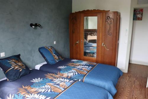 - une chambre avec deux lits et une armoire dans l'établissement 3 Aux Dames Vertes, à Cuzion