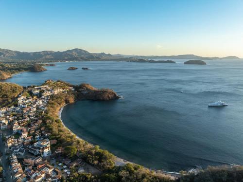 an aerial view of a beach with a boat in the water at Santarena Hotel at Las Catalinas in Playa Flamingo