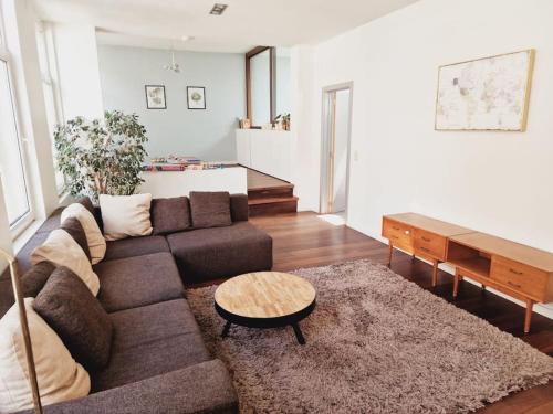 a living room with a couch and a table at Lightful architectural house in Ghent
