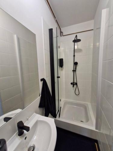 a white bathroom with a shower and a sink at Wrocławska 6 in Świdnica