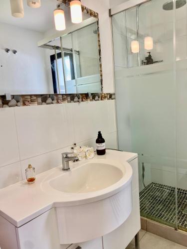 a white bathroom with a sink and a shower at Villa Hesla in Estepona