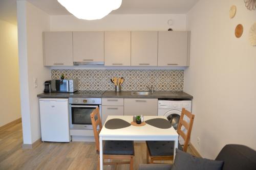 - une cuisine avec une table, une table et des chaises dans l'établissement Centre-ville à vos pieds, à Thonon-les-Bains