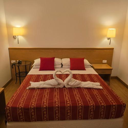two towels in the shape of hearts are on a bed at Hotel Marco Polo Airport hotel in Campalto