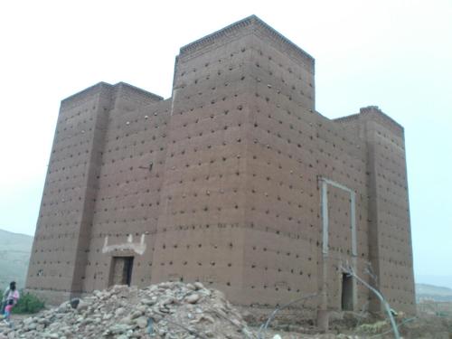 a large brick building on top of a pile of rubble at Casbah d'hôte La Jeanne Tourisme Ecologique in Boumalne