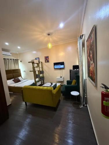 a bedroom with a bed and a yellow couch in a room at Cozy studio unit in lekki phase 1 - Kitchen, 24-7 light, wifi, Netflix in Lagos
