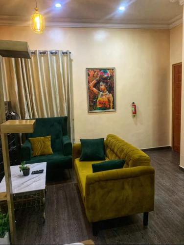 a living room with a yellow couch and a table at Cozy studio unit in lekki phase 1 - Kitchen, 24-7 light, wifi, Netflix in Lagos