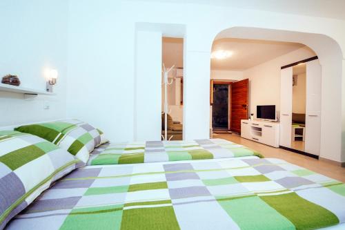 a bedroom with two beds with green and white at APARTMANI EMA in Zadar