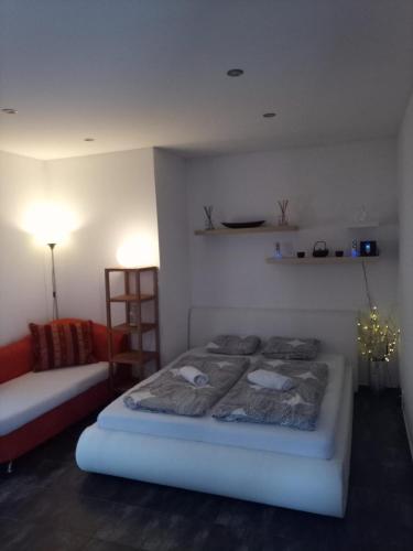 a white bedroom with a bed and a couch at Nižbor samostatný domek v zahradě in Nižbor