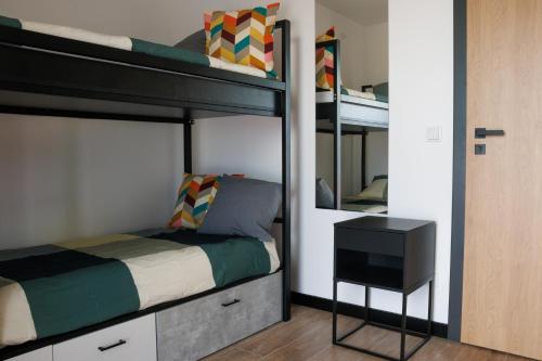 a bedroom with two bunk beds and a desk at Zeus Apartments Economy in Lublin