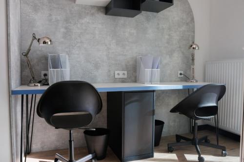 a desk with two chairs and a blue table at Zeus Apartments Economy in Lublin