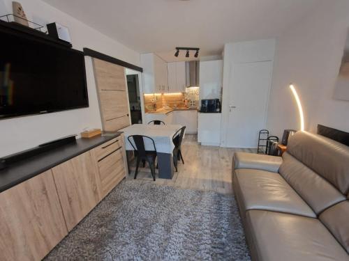 un salon avec un canapé et une table dans l'établissement Appartement cosy proche plage, à Cabourg