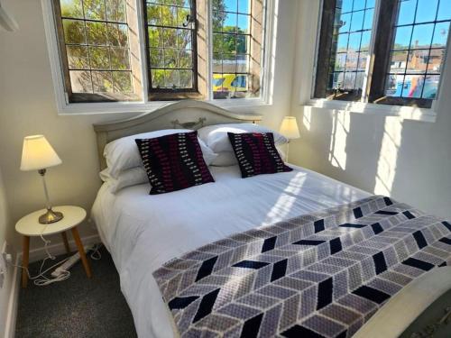 a bedroom with a bed with pillows and windows at Manor House, Modern 2-Bedroom Apartment, Parking, WiFi, Central Location in Kidlington