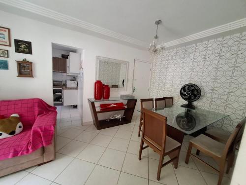 a living room with a pink couch and a table at Ilhéus Temporada in Ilhéus