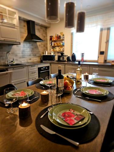 eine Küche mit einem Tisch mit Tellern und Weingläsern in der Unterkunft Villa Pare in Rovaniemi