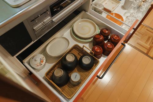an open refrigerator with plates and other dishes in it at 海の陽 in Nonami