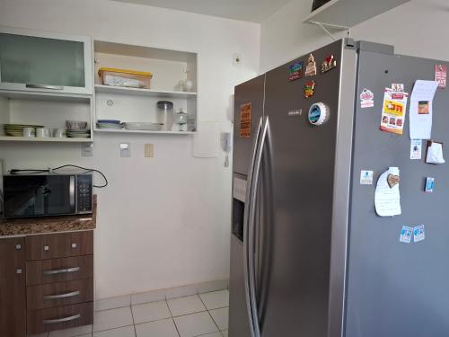 a kitchen with a stainless steel refrigerator with magnets at Ilhéus Temporada in Ilhéus