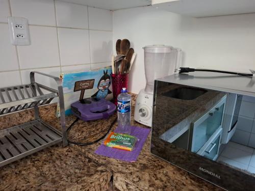 a kitchen counter with a counter top with a kitchen utensils at Ilhéus Temporada in Ilhéus
