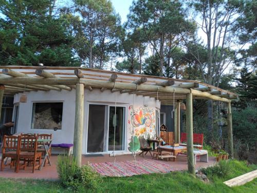 ein Haus mit einer Terrasse mit Tisch und Stühlen in der Unterkunft Infinito in Punta del Este
