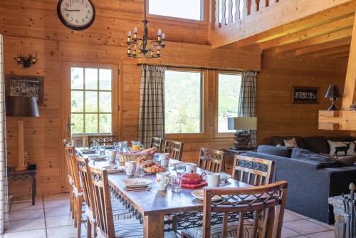 une salle à manger avec une longue table et des chaises dans l'établissement Chalet Ruisseau, aux Gets