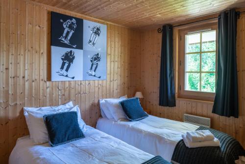 - 2 lits dans une chambre dotée de lambris dans l'établissement Chalet Ruisseau, aux Gets