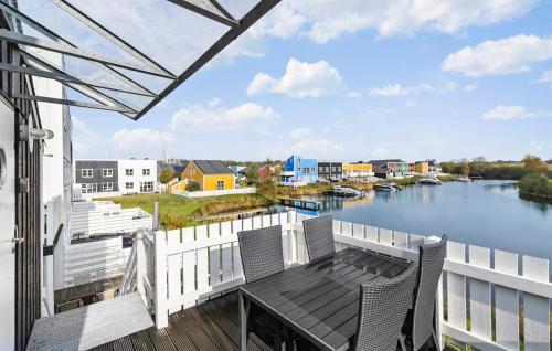 a balcony with a table and chairs overlooking a river at Rejen 223 in Ebeltoft