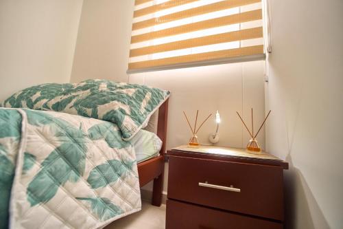 a bedroom with a bed and a dresser and a window at Apartamentos Amoblados Confort Turismo en Cúcuta in Cúcuta