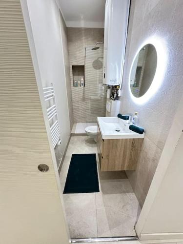 une salle de bain avec un lavabo, des toilettes et un miroir dans l'établissement Appartement calme - 2 chambres - Proche promenade, à Nice
