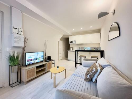 un salon avec un canapé et une télévision dans l'établissement Appartement calme - 2 chambres - Proche promenade, à Nice