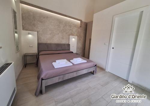 a bedroom with a bed with two towels on it at Giardino D'Oriente in Otranto