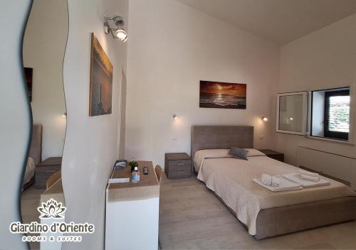 a bedroom with a bed and a desk and a window at Giardino D'Oriente in Otranto