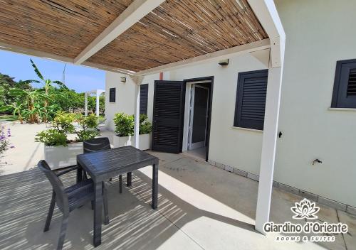 a table and chairs on the porch of a house at Giardino D'Oriente in Otranto