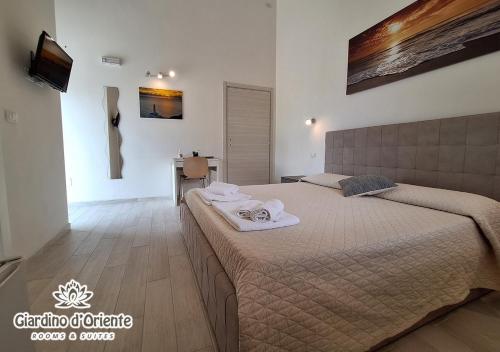 a bedroom with a large bed with towels on it at Giardino D'Oriente in Otranto