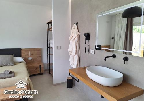 a bathroom with a sink and a bed and a mirror at Giardino D'Oriente in Otranto