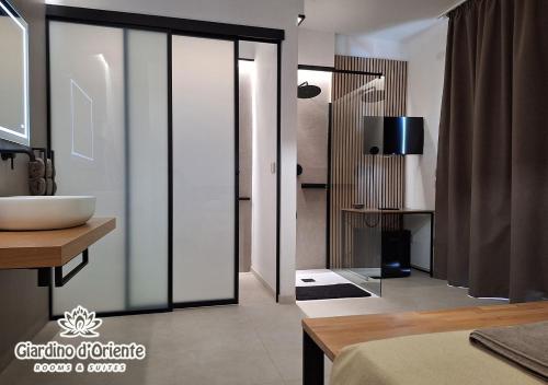 a bathroom with a sliding glass door with a sink at Giardino D'Oriente in Otranto