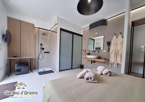 a bedroom with a large bed with towels on it at Giardino D'Oriente in Otranto