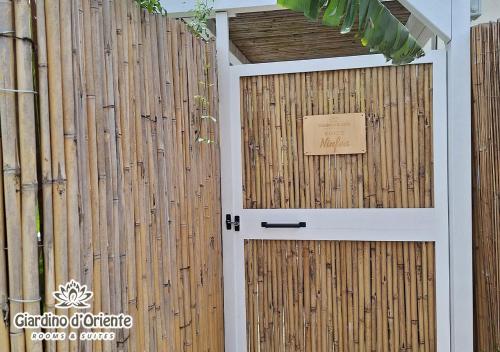 a wooden fence with a door with a sign on it at Giardino D'Oriente in Otranto