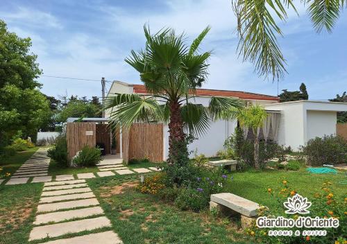 a house with a palm tree in the yard at Giardino D'Oriente in Otranto