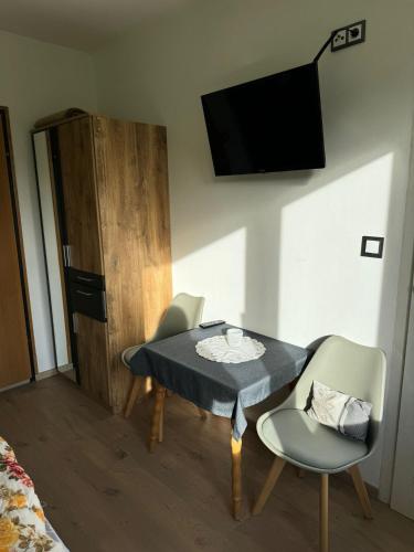 a room with a table and two chairs and a television at Haus Alpenland in Mariazell