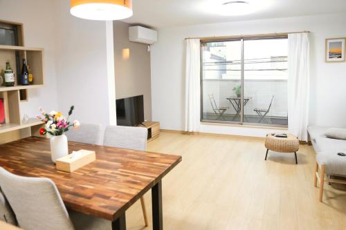 a living room with a wooden table and a dining room at 雅舍11 Osaka house new open一軒家貸切 in Osaka