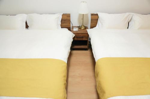 two beds sitting next to each other in a room at 雅舍11 Osaka house new open一軒家貸切 in Osaka