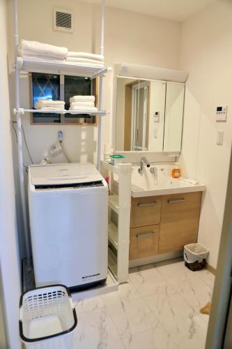 a bathroom with a sink and a vanity with a mirror at 雅舍11 Osaka house new open一軒家貸切 in Osaka
