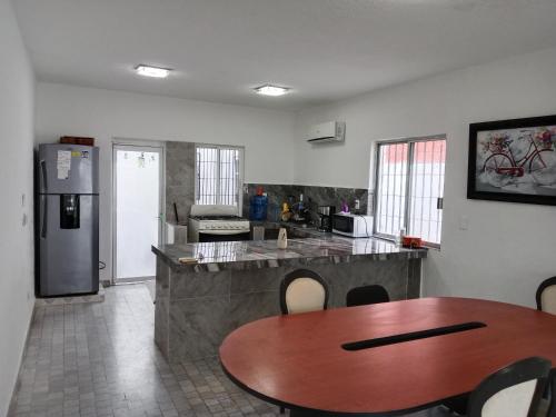 una cocina con una mesa y un refrigerador en Hostal Dream gunther, en Cancún