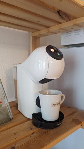 a coffee machine sitting on a counter with a cup at Appartamento Nerium - Cala di Seta in Calasetta
