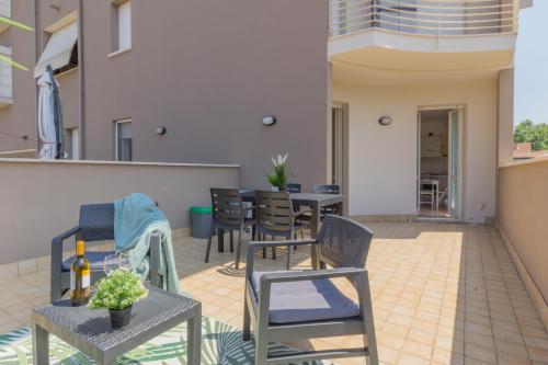 a patio with chairs and tables and a building at Crema, terrazza, a pochi passi dal centro città in Crema