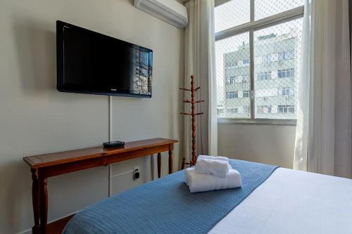 Un dormitorio con una cama y un televisor de pantalla plana. en Agradável apartamento próximo a Praia de Ipanema, en Río de Janeiro