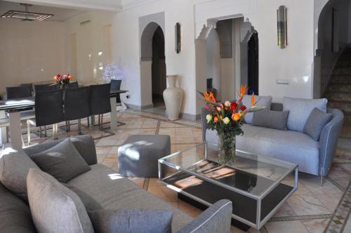 - un salon avec des canapés et une table avec des fleurs dans l'établissement Villa Palmeraie, à Marrakech