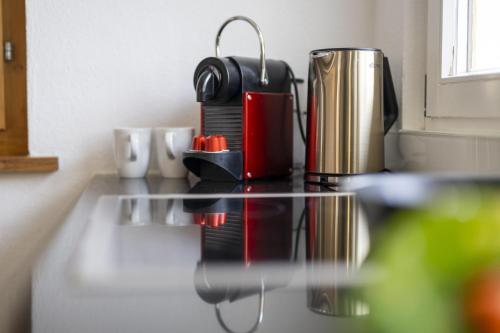 a counter top with a coffee maker and cups on it at Chasa Arquint in Sent